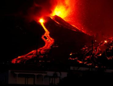 Lava flows next to a house following the eruption of a volcano in the Cumbre Vieja national park at El Paso, on the Canary Island of La Palma, September 19, 2021. REUTERS/Borja Suarez